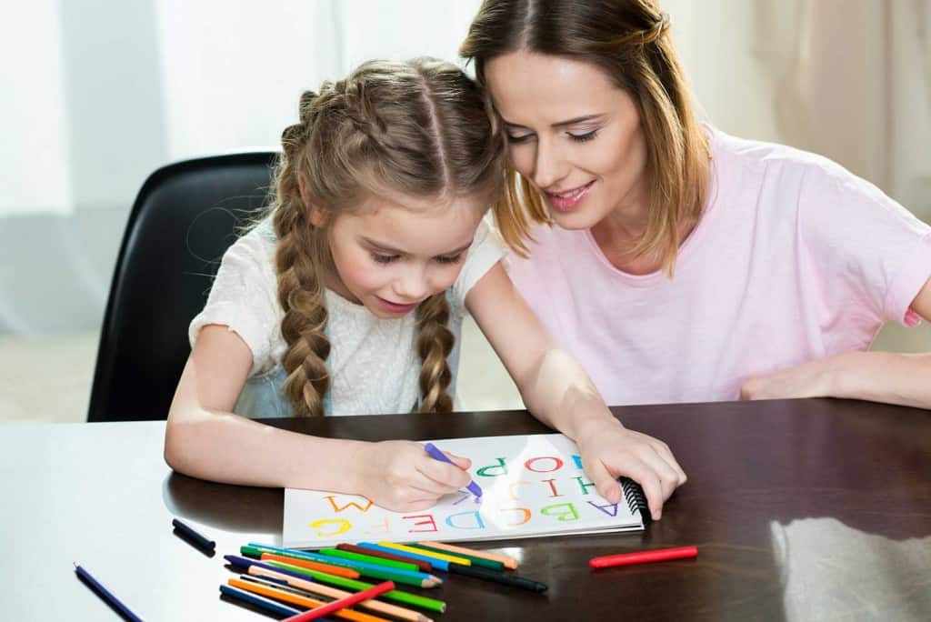 homeschool mom teaching the ABCs to her daughter
