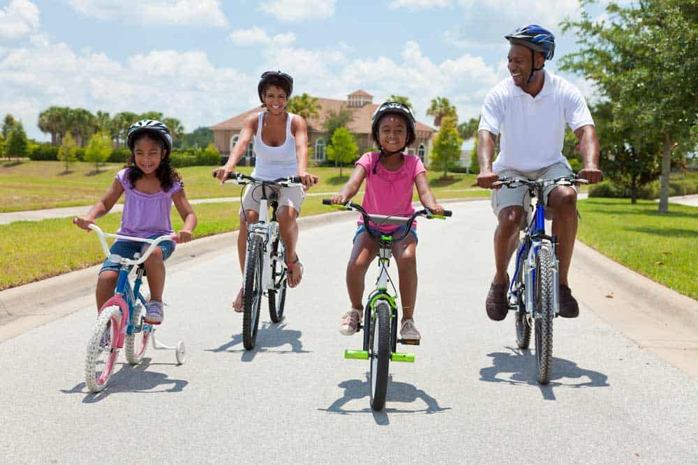 family riding bikes in their neighborhood