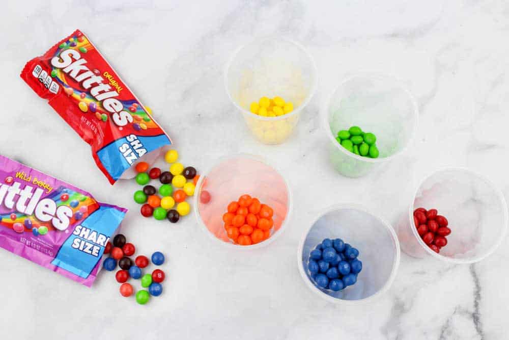 Skittles candies in plastic cups seperated by color