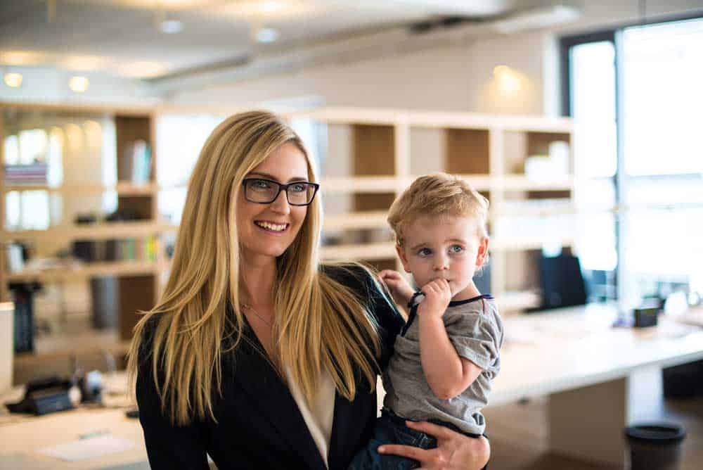 working mom in her office holding son